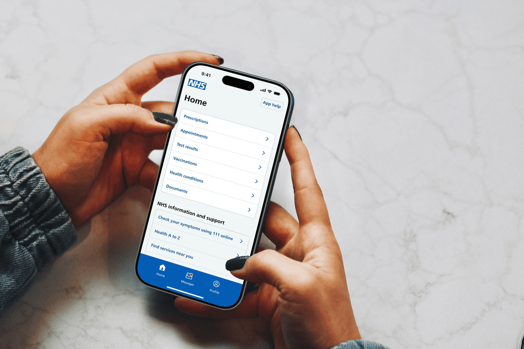 The hands of a person using the NHS app on their phone