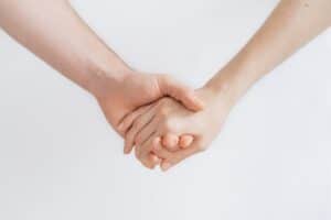Two people holding hands, only  arms visible