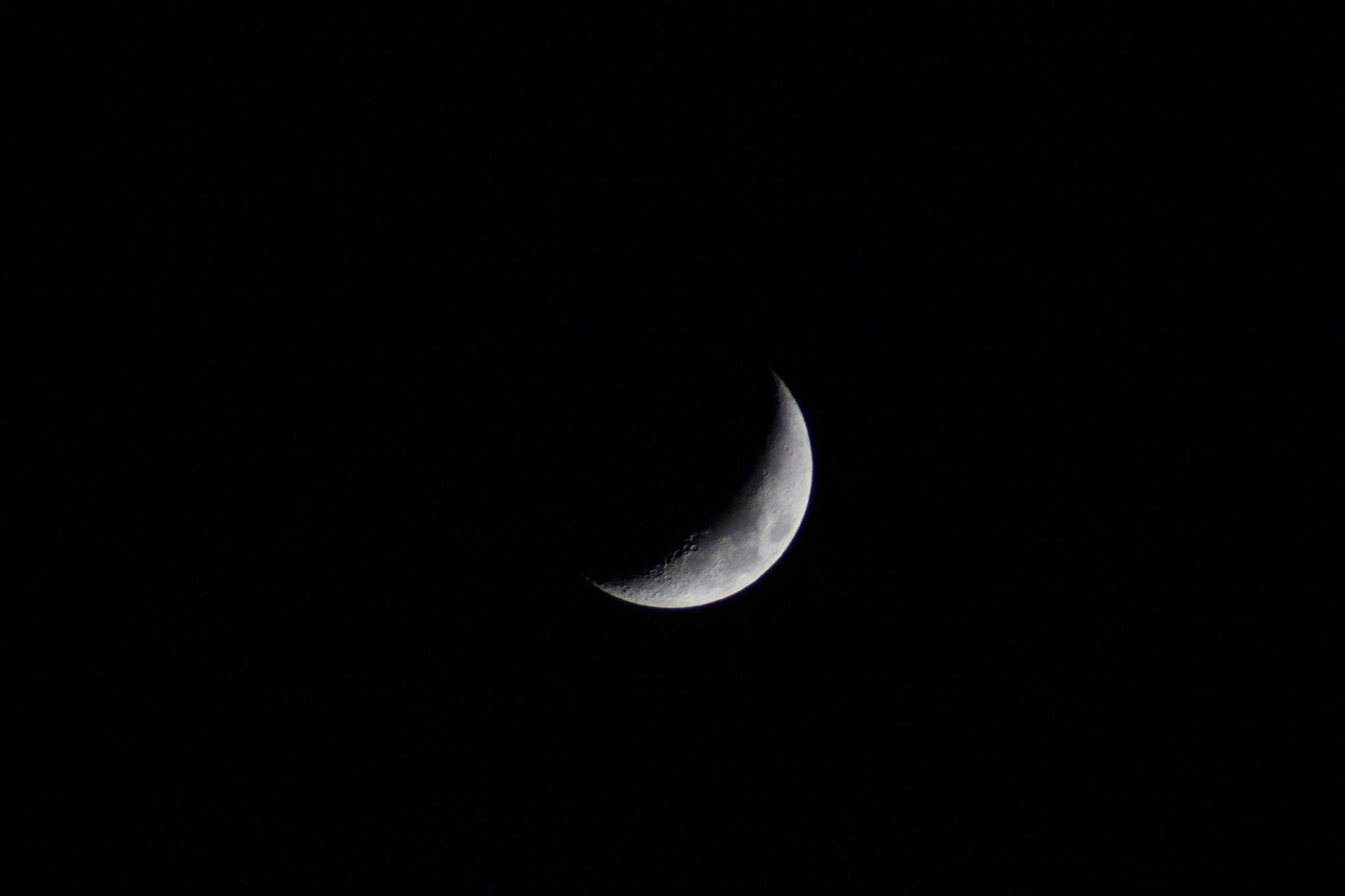 A crescent moon in a black sky
